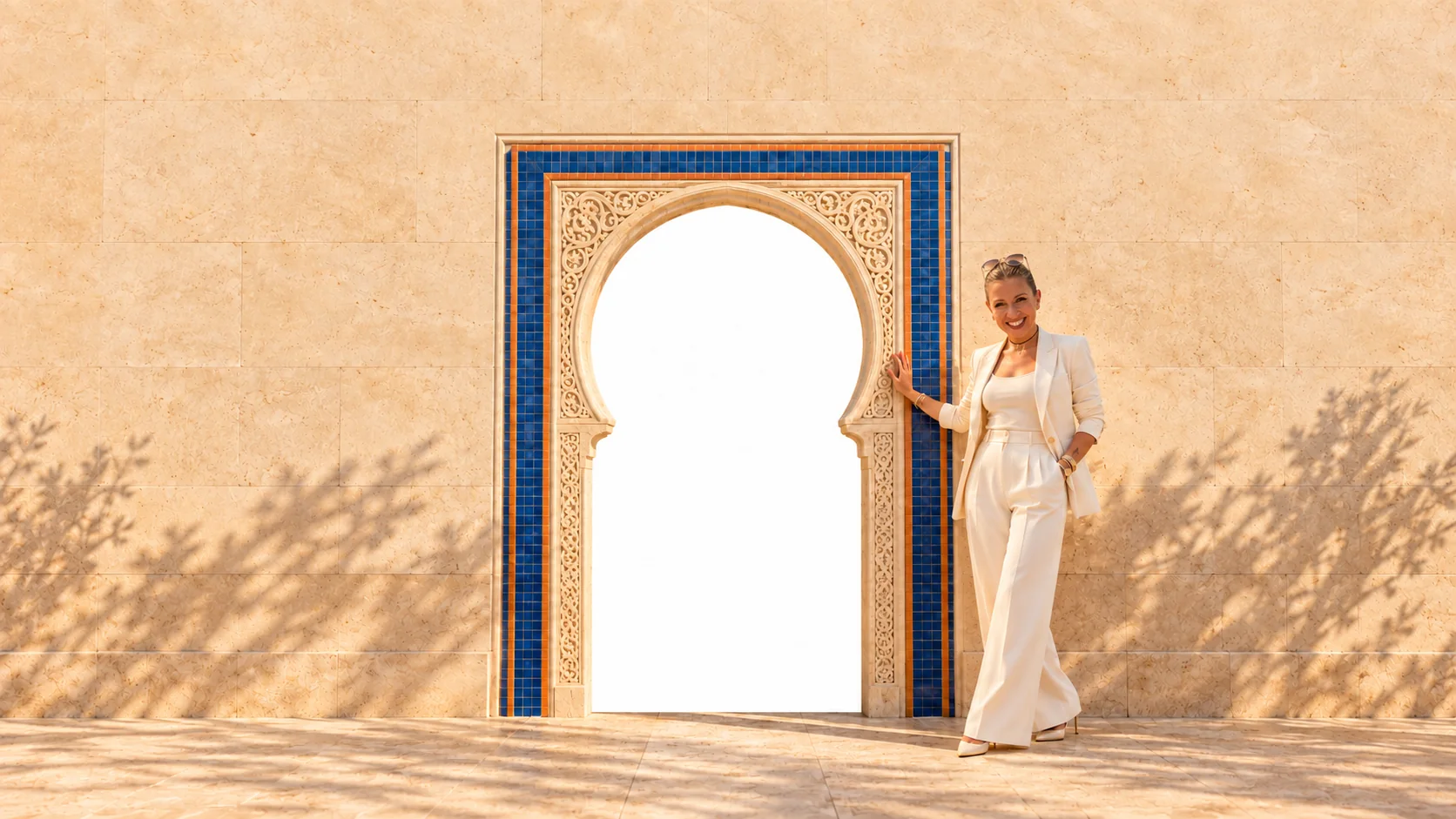 Hala Hijazi beside a cobalt-tiled arch in golden light