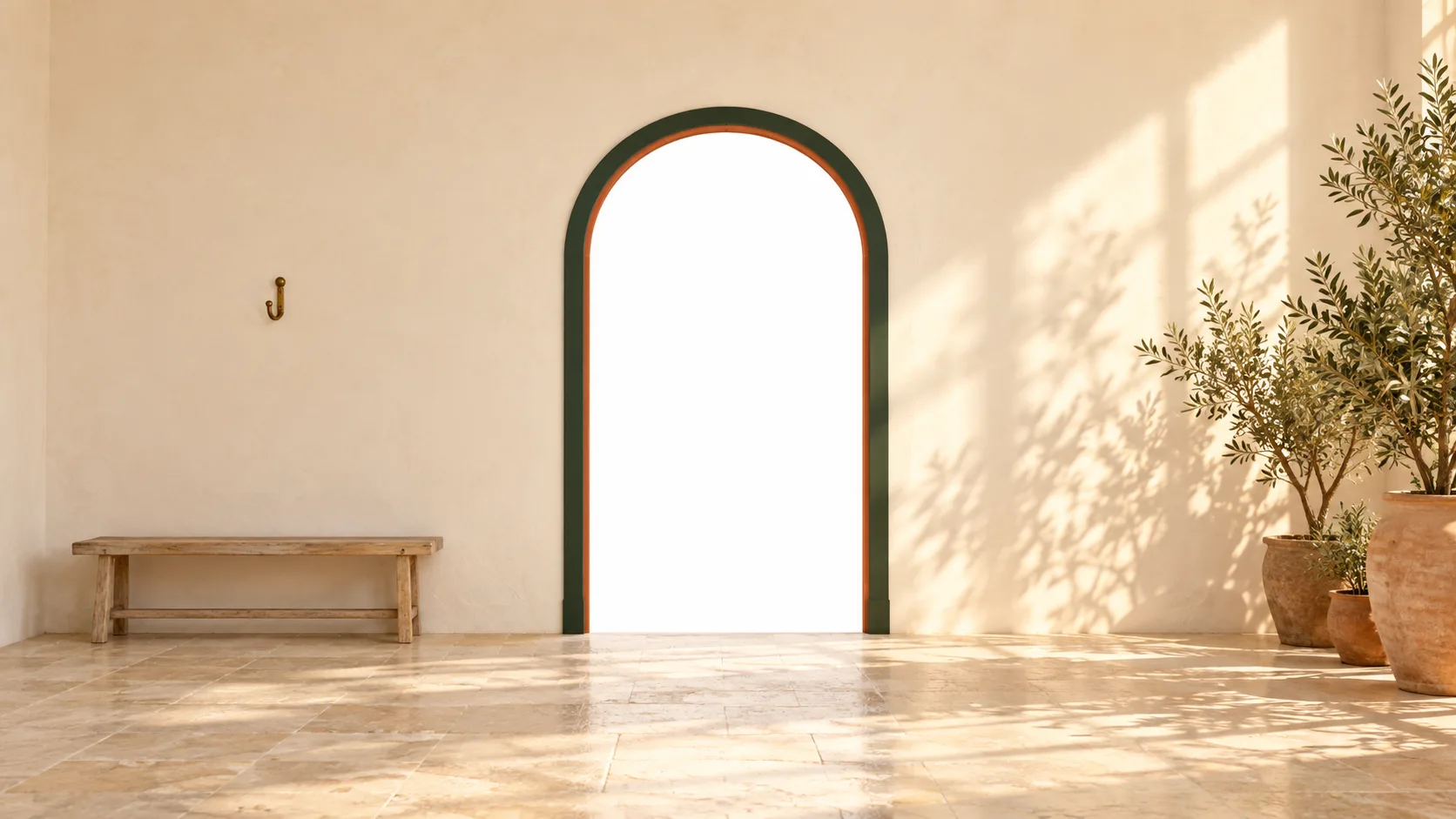 A sunlit artist's studio with cream walls, olive trees and an arched doorway